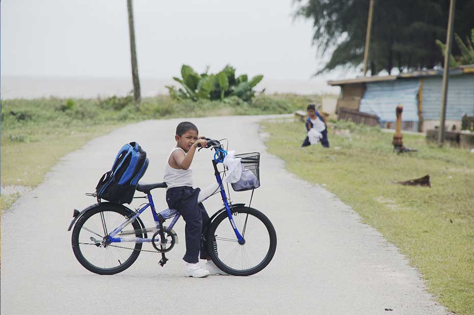 A schoolboy tackles the country road in Pahang.