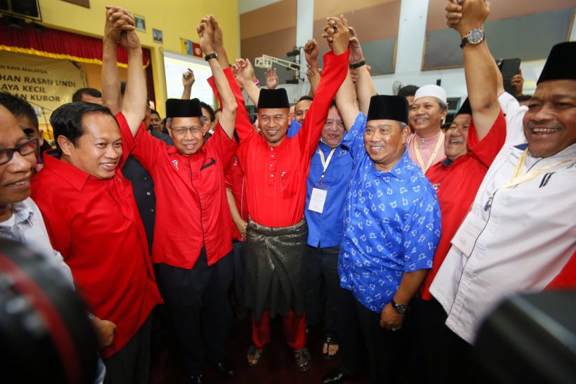 Umnou00e2u20acu2122s Mat Razi Mat Ail (centre) raises his hand in victory after garnering a majority over PASu00e2u20acu2122s Wan Rosdi Wan Ibrahim, September 25, 2014. u00e2u20acu201d Picture by Saw Siow Feng