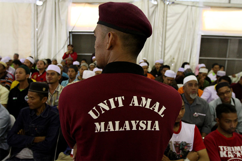 A member of PAS' volunteer corps, Unit Amal, steps in to control the crowd during Mohamed Hanipa Maidin speech at PAS' 60th Muktamar in Batu Pahat, September 20, 2014. u00e2u20acu2022 Picture by Yusof Mat Isa