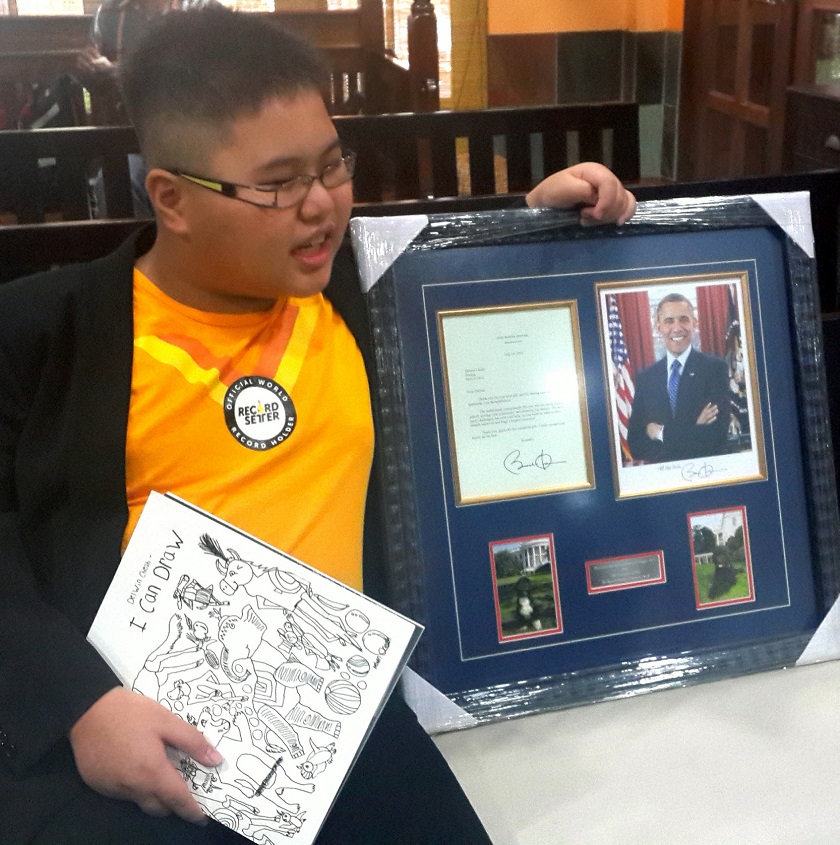 Malaysiau00e2u20acu2122s first autistic savant artist, Delwin Cheah Wien Loong, 11, shows the letter of recognition he received from United States President Barack Obama dated July 14, and a photograph signed with well-wishes. u00e2u20acu201d Bernama pic