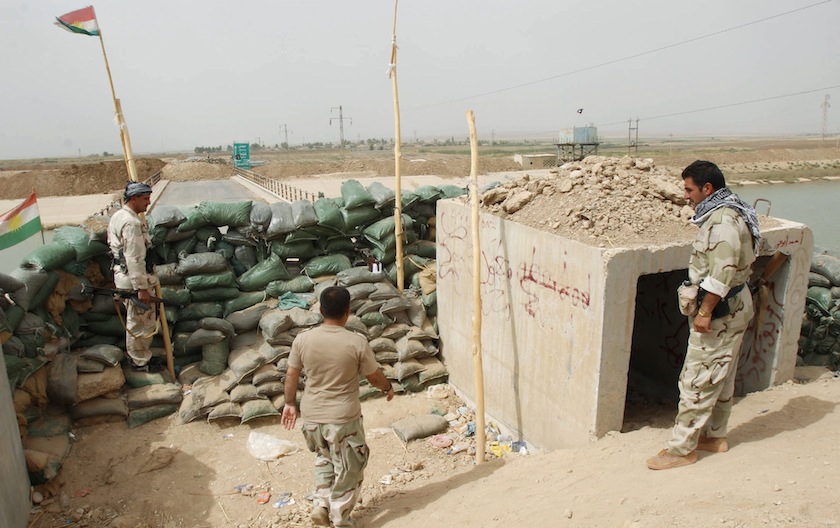 Members of the Kurdish security forces stand guard against Islamic State militants (background), behind sandbags on the Mullah Abdullah bridge in southern Kirkuk September 29, 2014. u00e2u20acu201d Reuters pic