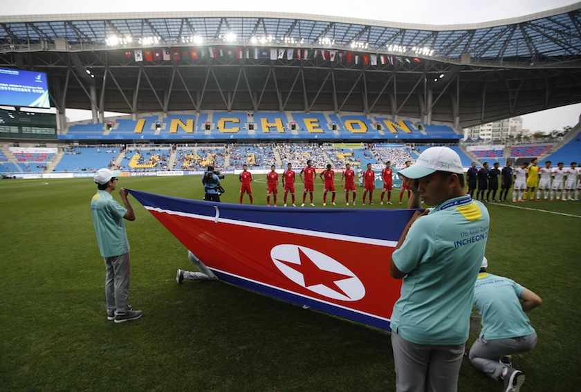 South Korean volunteers hold North Korean national flag as North Korean team players wait for their men's qualifier match against China for the 17th Asian Games at Incheon Football Stadium September 15, 2014.u00c2u00a0u00e2u20acu201du00c2u00a0Reuters pic