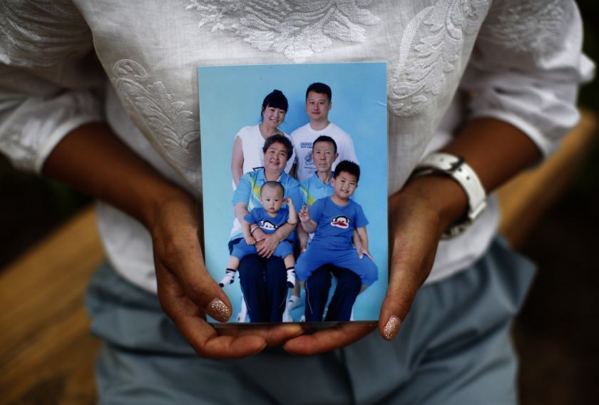 Cheng Liping, whose husband Ju was onboard Malaysia Airlines Flight MH370, shows a family photo featuring her missing husband (top right), during an interview with Reuters in Beijing July 24, 2014.  u00e2u20acu201d Reuters pic