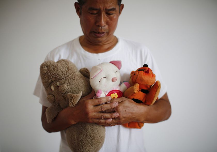 Zhang Yongli, whose daughter Zhang Qi was onboard Malaysian Airlines Flight MH370 which disappeared on March 8, 2014 looks at his daughter's plush toys as he poses for a picture, during an interview with Reuters in Beijing July 22, 2014. — Reuters pic