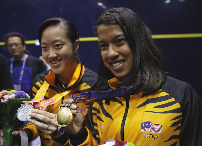 Gold medalist Nicol David of Malaysia shows her medal with her compatriot, silver medalist Low Wee Wern, during an award ceremony for the women's single squash match during the 17th Asian Games in Incheon September 23, 2014. u00e2u20acu201d Reuters pic