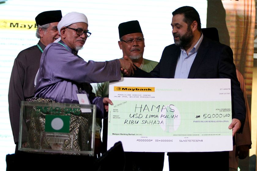 PAS president Datuk Seri Abdul Hadi Awang hands over a mock cheque to a representative of Palestinian resistance movement Hamas at the PAS 60th Muktamar in Batu Pahat, September 18, 2014. u00e2u20acu2022 Picture by Yusof Mat Isa