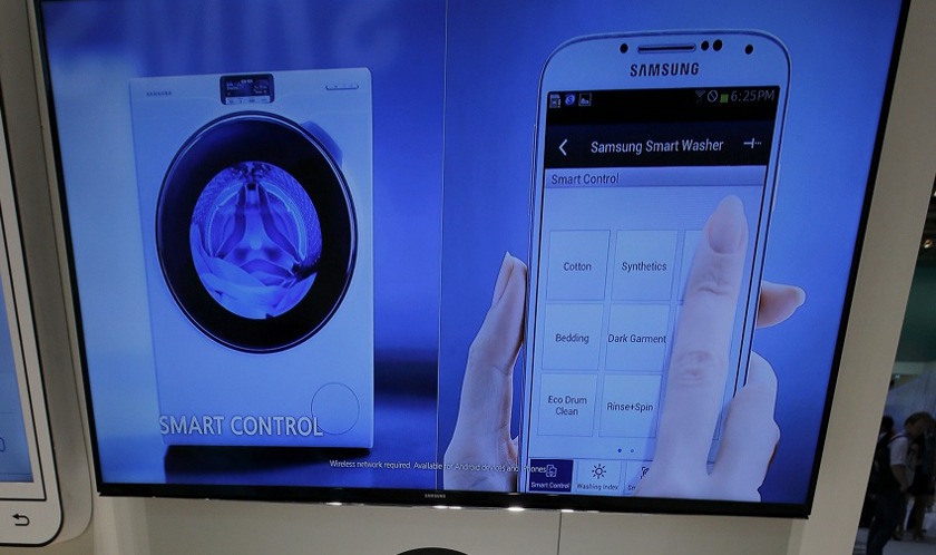 A Samsung employee holds a smartphone remotely controlling a WW9000 washing machine at the IFA consumer technology fair in Berlin, September 5, 2014. u00e2u20acu201d Reuters pic