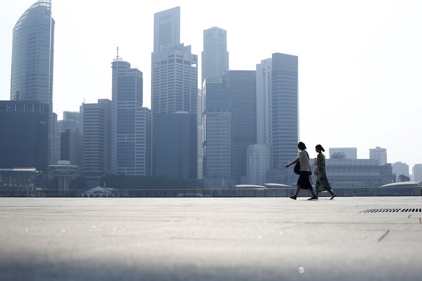 People walk past the skyline of the financial district on a hazy day in Singapore September 4, 2014.u00c2u00a0u00e2u20acu201d Reuters pic