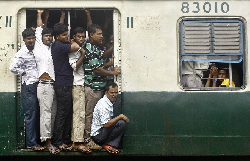 Commuters stand at an open doorway of a suburban train during the morning rush hour in Kolkata September 22, 2014. u00e2u20acu201d Reuters pic