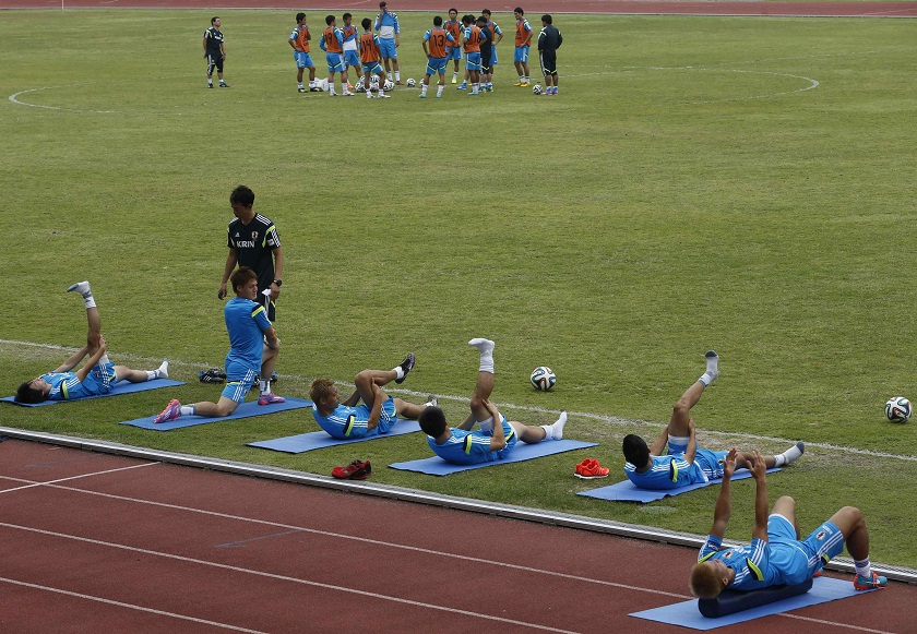 Japanu00e2u20acu2122s national football squad players stretch during a training session ahead of their friendly match against Brazil in Singapore, October 12, 2014. u00e2u20acu201d Reuters pic