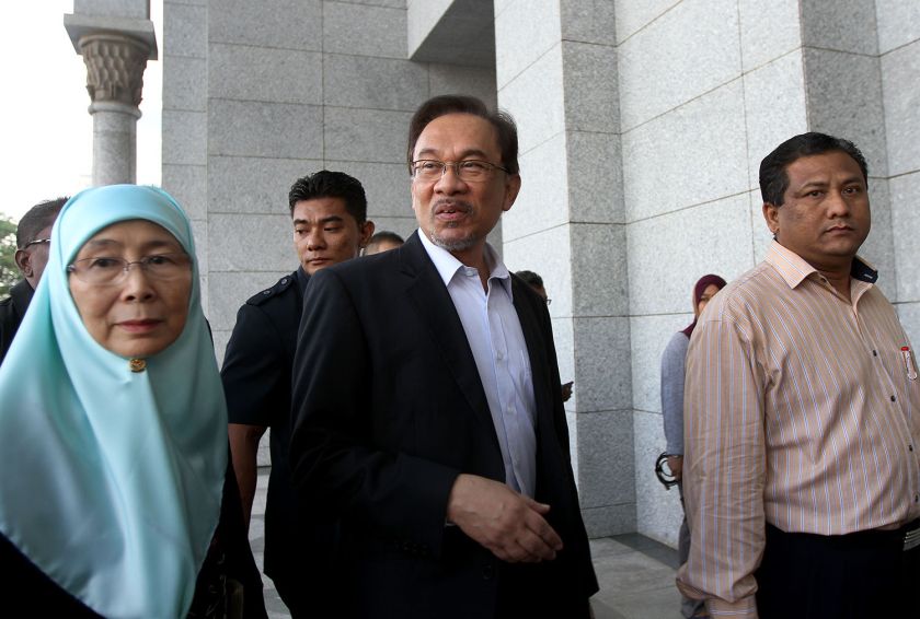 Datuk Seri Anwar Ibrahim and his wife Datum Seri Dr Wan Azizah Wan Ismail are escorted into the Palace of Justice in Putrajaya, October 28, 2014. u00e2u20acu2022 Picture by Yusof Mat Isa