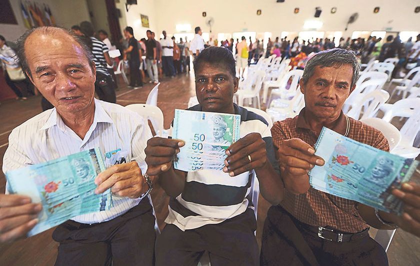 (From left) Lee Koon Po, 79, R. Krisahan, 56, and Samsudin Nayan, 58, show the BR1M aid worth RM500 they received in 2012. Many have benefited from the government scheme as the aid has been increased to RM950. u00e2u20acu201d File picture