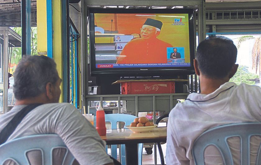 Customers watch the ‘live’ broadcast on Budget 2015 at a restaurant. — Picture by Hari Anggara