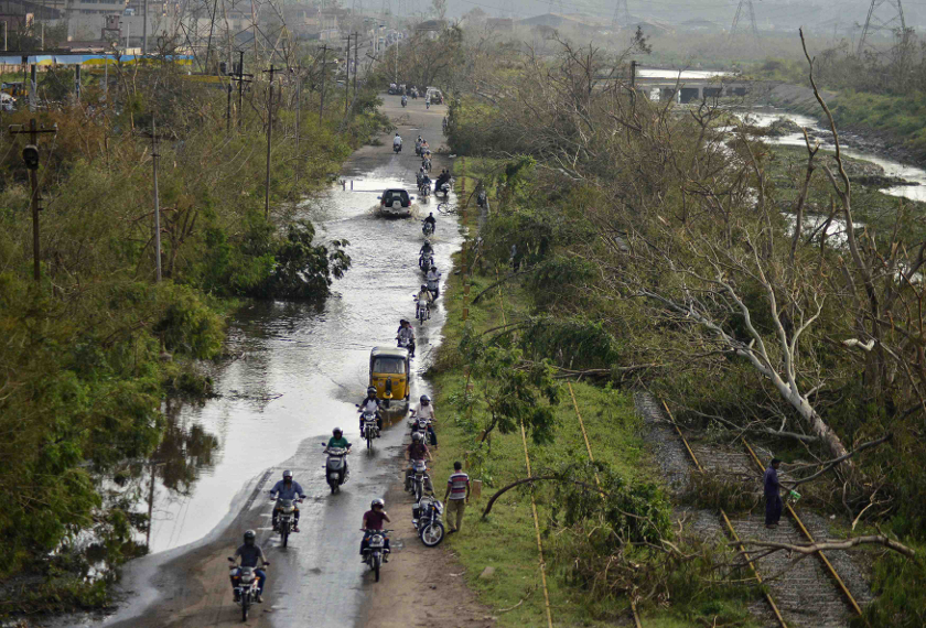 Vehicles move through a flooded road next to the trees fallen over railway tracks after being damaged by strong winds caused by the Cyclone Hudhud in the southern Indian city of Visakhapatnam October 14, 2014. u00e2u20acu201d Reuters pic 