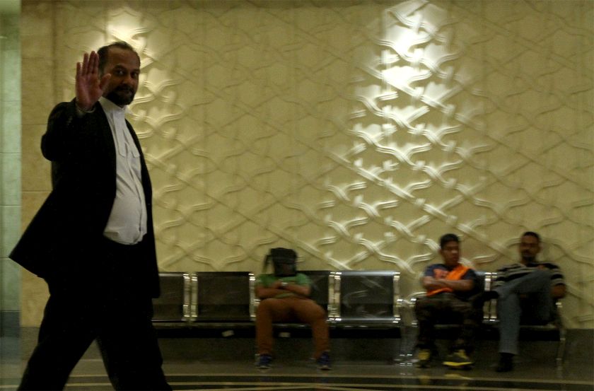 Gobind Singh Deo waves to reporters as he heads back to the court room after lunch break, October 19, 2014. u00e2u20acu201d Picture by Yusof Mat Isa