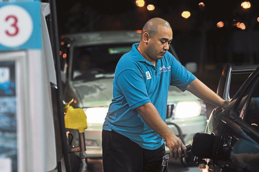 A man filling up his car at a petrol station. u00e2u20acu2022 Malay Mail pic