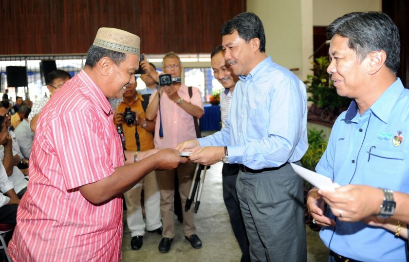 Negeri Sembila Menteri Besar Datuk Seri Mohamad Hasan handing a cheque to a recipient as compensation for reclaiming land in order to improve Sungai Simin, October 17, 2014. u00e2u20acu201d Bernama pic 