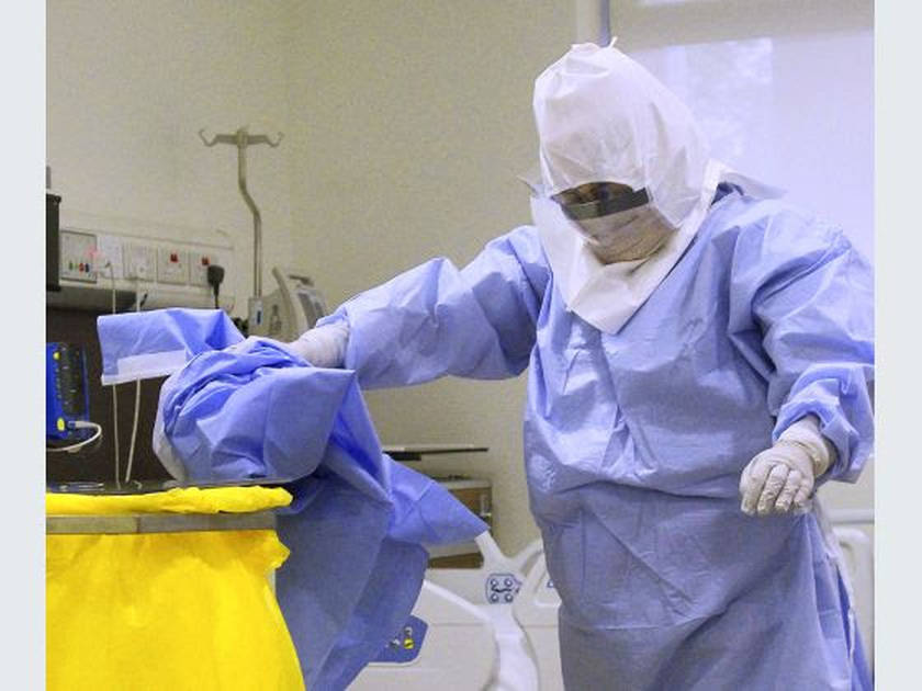 Senior staff nurse Naw Hser Bwe demonstrates the proper steps to taking off the Personal Protection Equipment (PPE) and disposing of it, October 24, 2014. u00e2u20acu201d TODAY pic