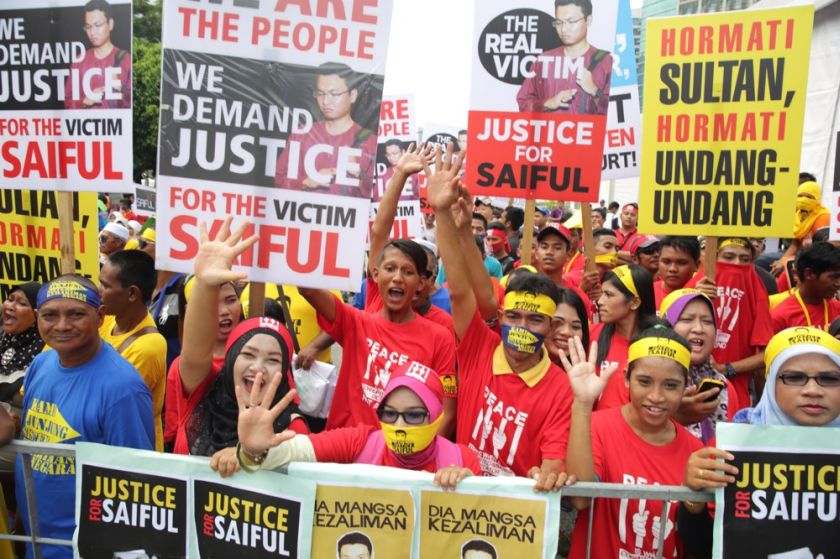 Saiful's supporters holding up placards on the other side of the Palace of Justice, October 29, 2014. — Picture by Choo Choy May