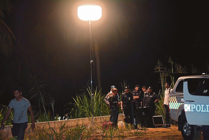 Abdul Rahim (third left) and Mazlan (second right) at the scene of the crime in Simpang Ampat. u00e2u20acu201d Malay Mail pic
