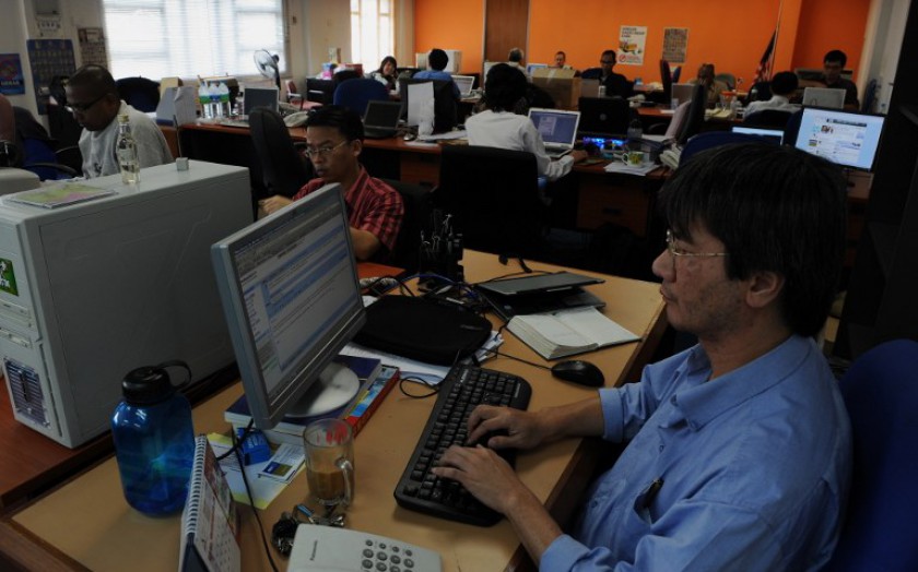 File picture shows Steven Gan (right), one of the founders of news website Malaysiakini, working on a story in his office in Kuala Lumpur. u00e2u20acu201d AFP pic