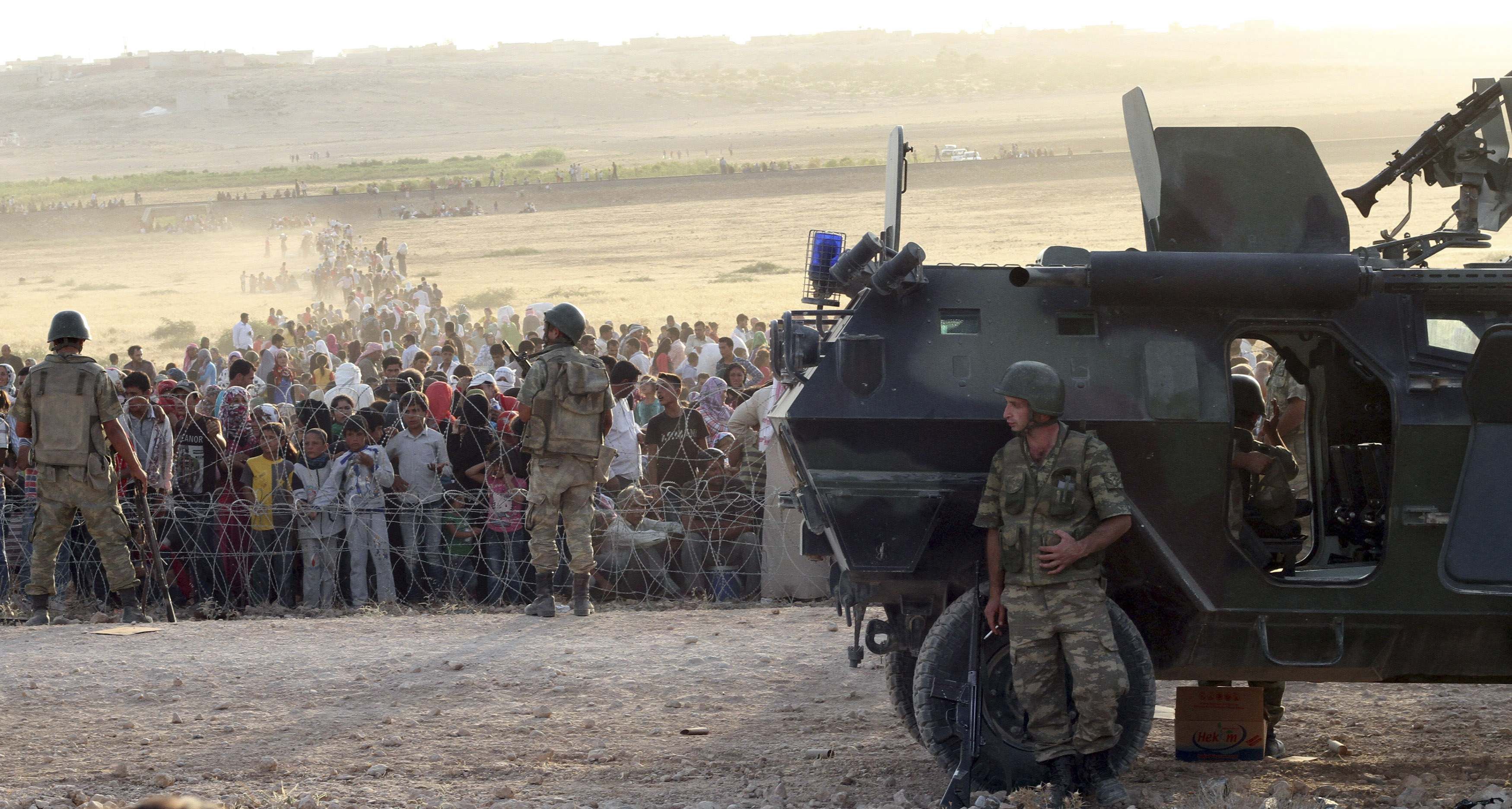 Turkish soldiers stand guard as Syrians wait behind the border fences near the south-eastern town of Suruc in Sanliurfa province in this September 18, 2014. u00e2u20acu2022 Reuters pic