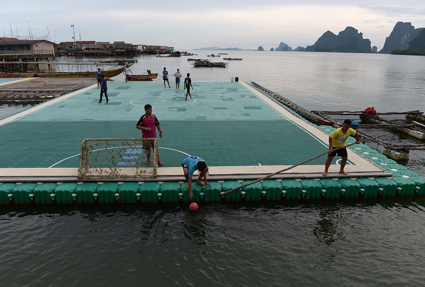 Youngsters recovering a football from the water as they play on a floating football pitch in Koh Panyee on October 1. u00e2u20acu201d AFP pic