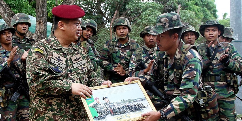 Raja Muda of Perlis Tuanku Syed Faizuddin Putra Jamalullail (left) presents a plaque to Regiment 504 platoon leader of the armed forces at Pulau Mandi Darah near Kudat, Sabah in this July 4, 2014 file picture. u00e2u20acu201d Bernama pic
