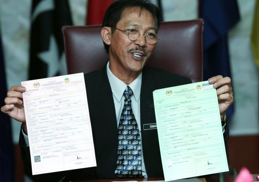 Sabah National Registration Department director Ismail Ahmad holding two specimen birth certificates of different colour, one for Malaysians and another for non-Malaysians. u00e2u20acu201d Picture by Julia Chan