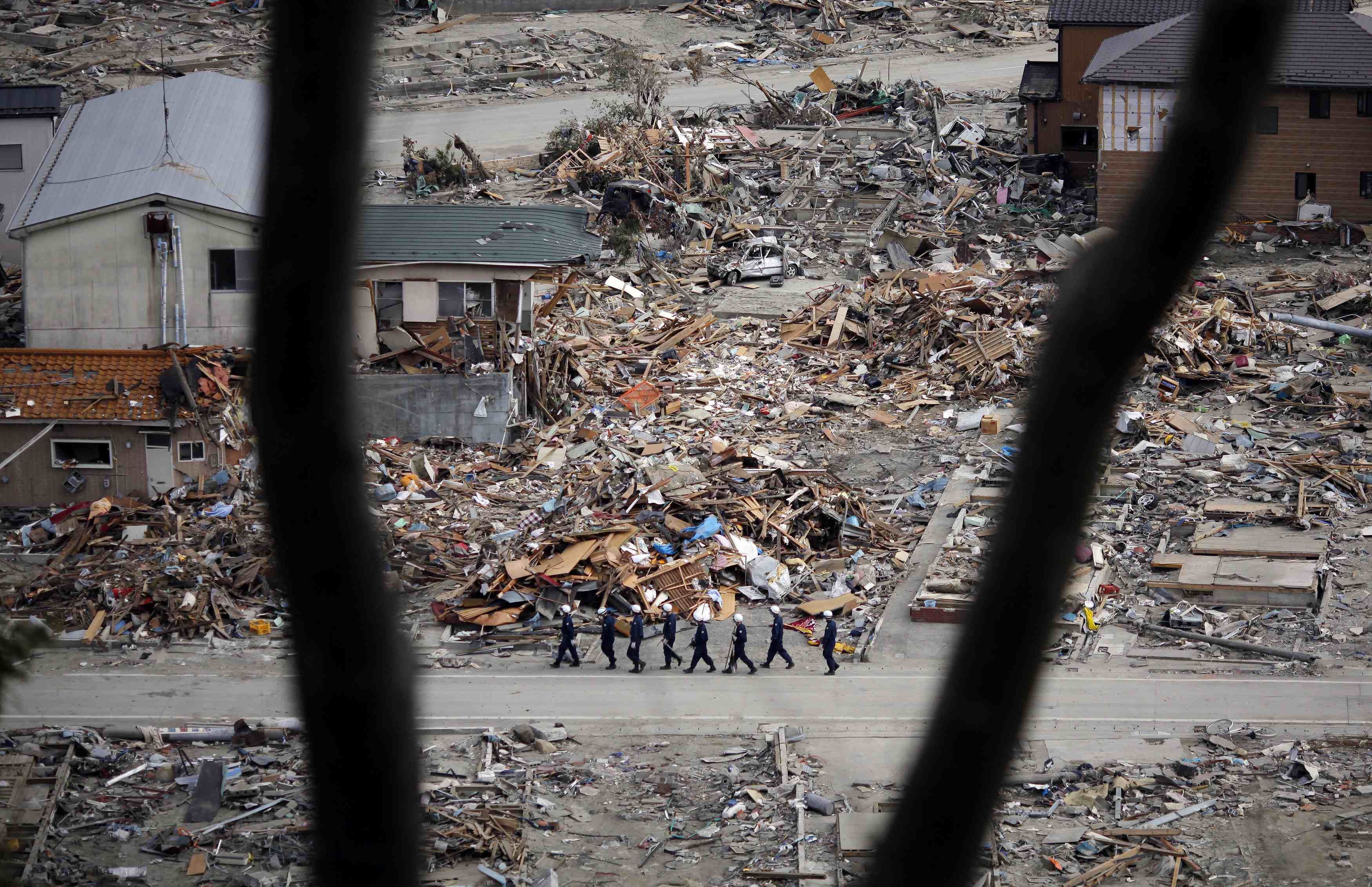 Members of a search and rescue team walk in an area destroyed by the March 11 earthquake and tsunami in Ishinomaki, northern Japan in this April 4, 2011 file photo. u00e2u20acu201d Reuters pic