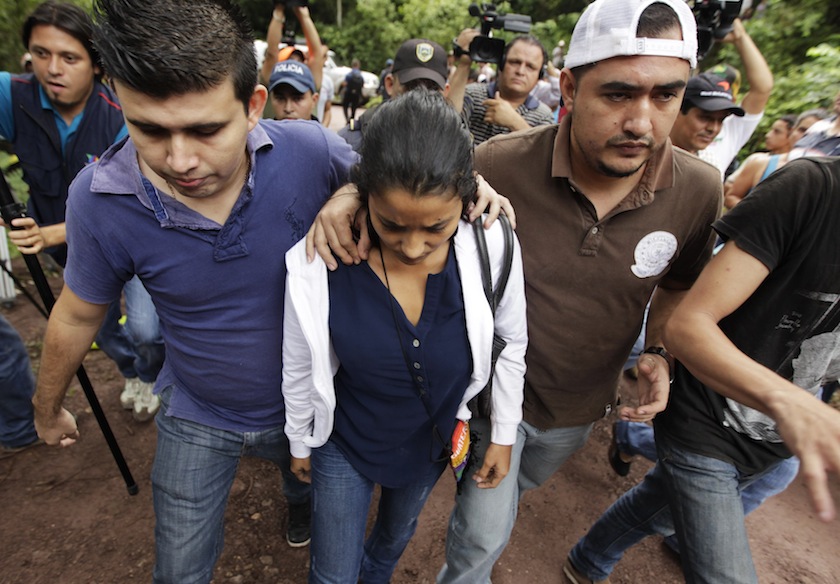 A relative (centre) of Maria Jose and Sofia Alvarado leaves a crime scene in Arada November 19, 2014.u00c2u00a0u00e2u20acu201d Reuters pic