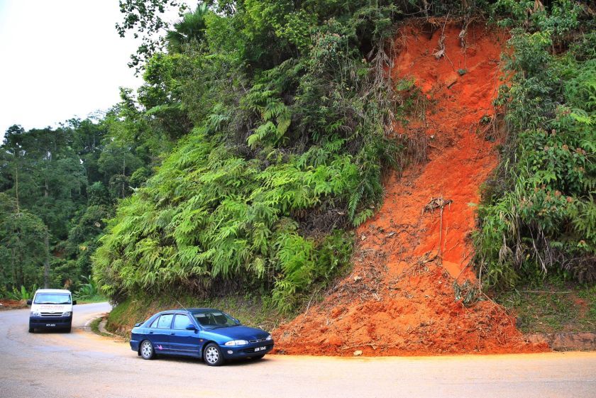 Cars head up to Cameron Highlands, passing by a slope that is left bare after being hit by a small landslide. u00e2u20acu201d Picture by Saw Siow Feng