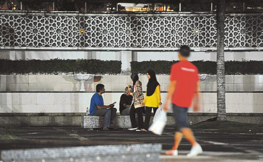 A Samaritan hands a bun and mosquito coil to Alam. u00e2u20acu2022Picture by Nazerul Ramli