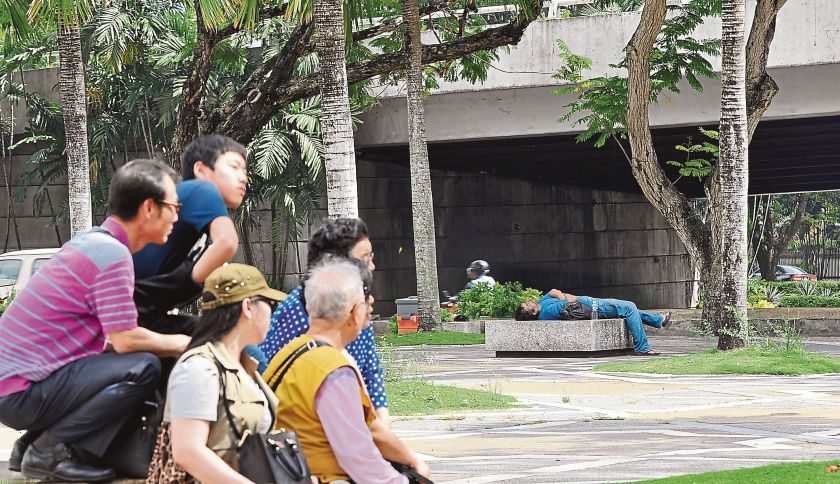 A group of tourists looks at Alam while he is resting on the slab of cold stone. u00e2u20acu2022 Picture by Nazerul Ramli