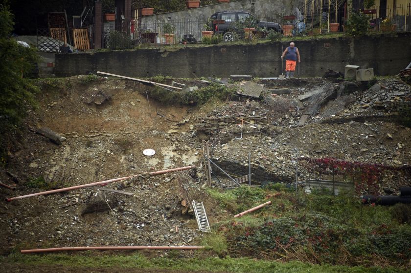 A man looks at damages of a landslide in his yard following heavy rain in Gavi, on October 14, 2014. u00e2u20acu201d AFP pic