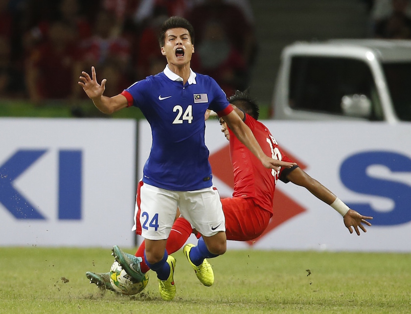 Malaysiau00e2u20acu2122s Mohamad Muslim Bin Ahmad is tackled by Singaporeu00e2u20acu2122s Mohammad Khairul Amri Bin Mohammad Kamal during their AFF Suzuki Cup Group B match in Singapore November 29, 2014. u00e2u20acu201d Reuters pic