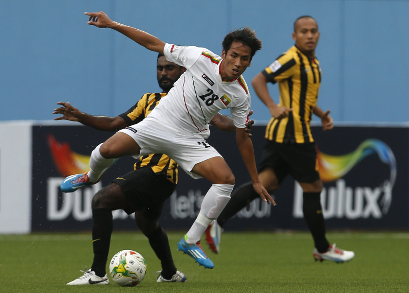Malaysia's Gary Steven Robbat (left) challenges Nanda Lin Kyaw Chit during their Suzuki Cup Group B match at Jalan Besar stadium in Singapore November 23, 2014. u00e2u20acu201d Reuters picn