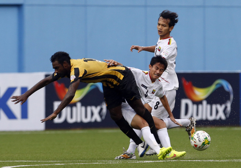 Malaysia's Gary Steven Robbat is challenged by Myanmar's David Htan (4) and Min Min Thu during their Suzuki Cup Group B match at Jalan Besar stadium in Singapore November 23, 2014. u00e2u20acu201d Reuters pic