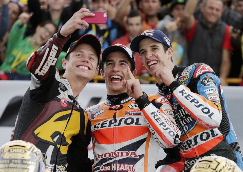 Spanish world champions MotoGP rider Marc Marquez (C), Moto2 rider Esteve Rabat (L) and Moto3 rider Alex Marquez take a selfie at the end of the Valencia Motorcycle Grand Prix at the Ricardo Tormo racetrack in Cheste November 9, 2014. REUTERS
