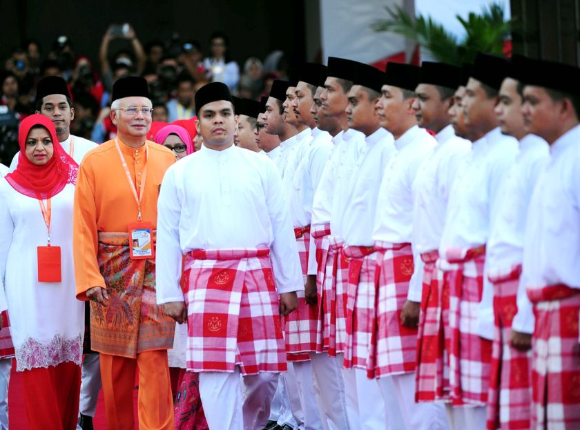 Datuk Seri Najib Tun Razak (in orange) inspects the parade, mounted by 150 members of the three Umno wings, Wanita, Youth and Puteri, at the opening of the 2014 Umno General Assembly, November 27, 2014. u00e2u20acu201d Bernama pic