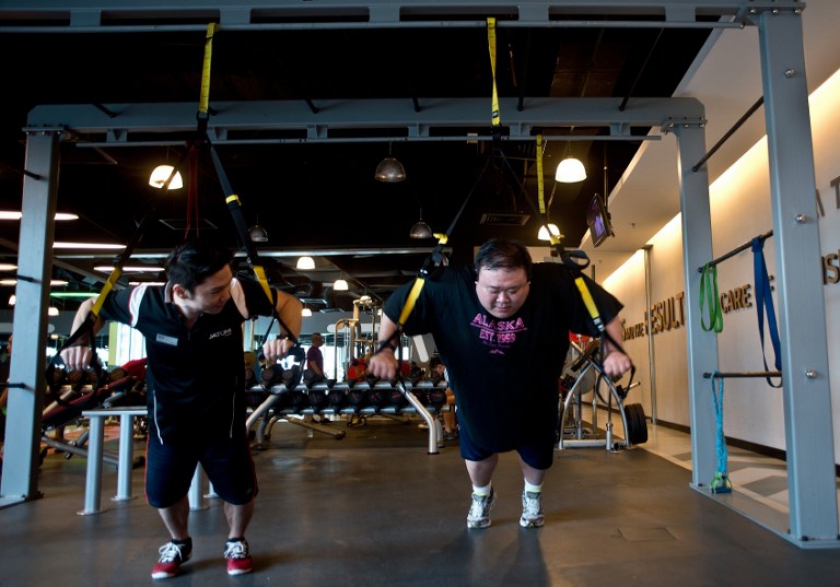 Picture taken September 12, 2014, shows 40-year-old Malaysian civil engineer Kevin Lim (right) working out at the fitness centre in Kuala Lumpur. u00e2u20acu201d AFP pic
