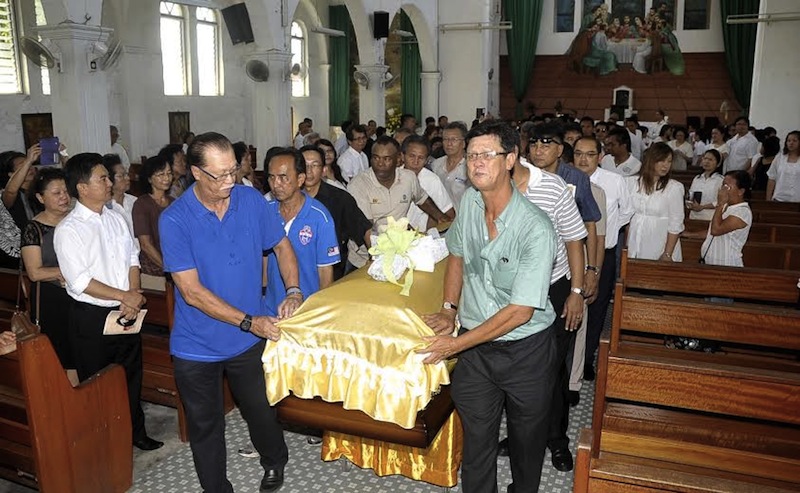 The late Sabahan football legend Peter Rajah’s coffin was carried out by of the St Michael’s Catholic church in Penampang by former teammates and those closest to him including James Wong and Hassan Sani. — Picture by Julia Chan 