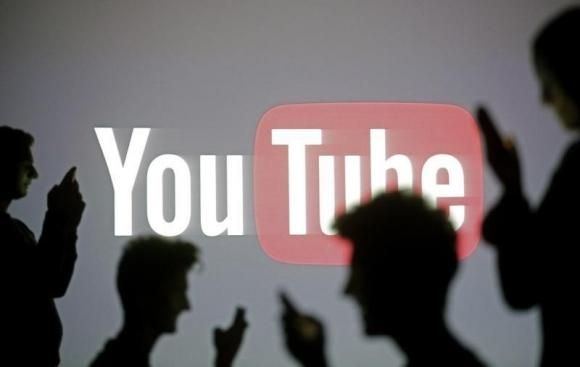 People are silhouetted as they pose with mobile devices in front of a screen projected with a YouTube logo, in this picture illustration taken in Zenica October 29, 2014. Reuters