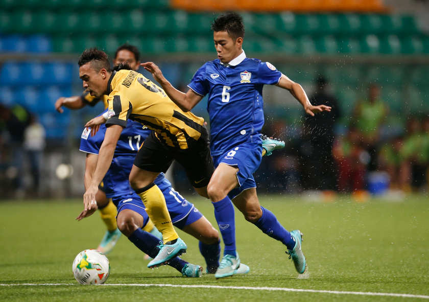 Malaysia's Norshahrul Idlan Talaha is challenged Thailand's Sarach Yooyen (right) during their Suzuki Cup Group B match at Jalan Besar Stadium in Singapore, November 26, 2014. u00e2u20acu201d Reuters pic
