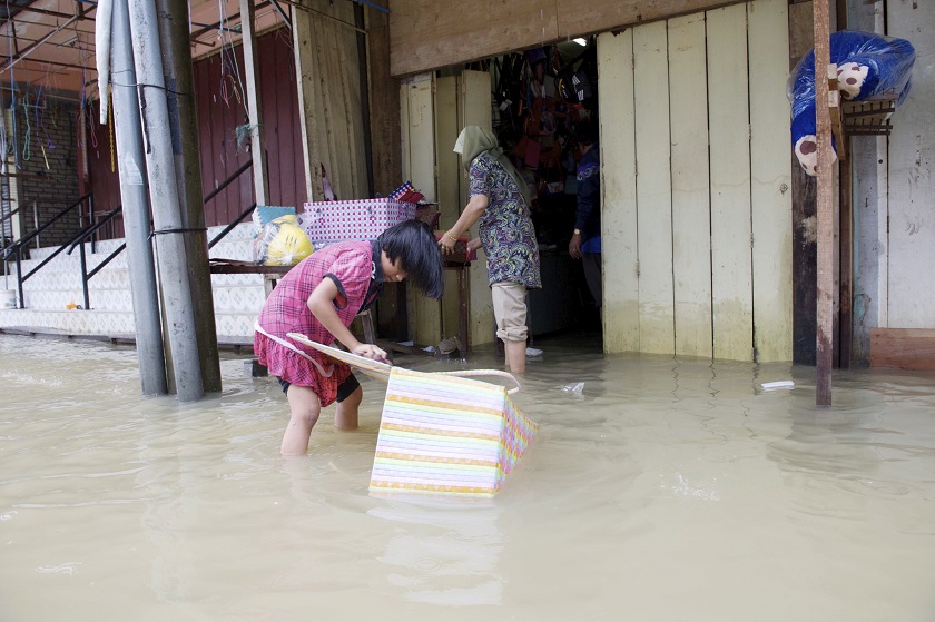 A child helps her mother collect items from their shop which were destroyed in a flood in Rantau Panjang, December 22, 2014.u00e2u20acu201d Bernama pic