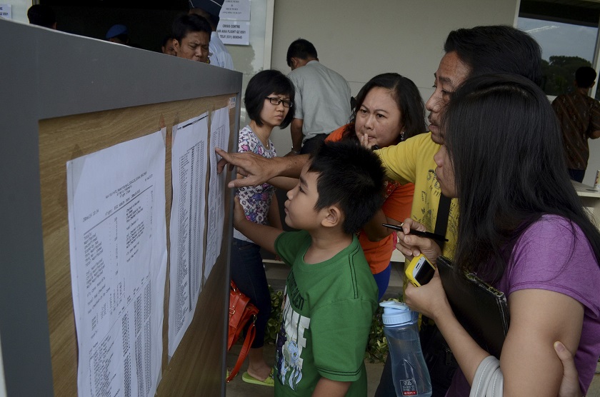 Family members of passengers on board Indonesia AirAsia flight QZ8501 look at a passenger list inside a crisis centre at Juanda Airport in Surabaya, East Java December 28, 2014. u00e2u20acu201d Reuters pic