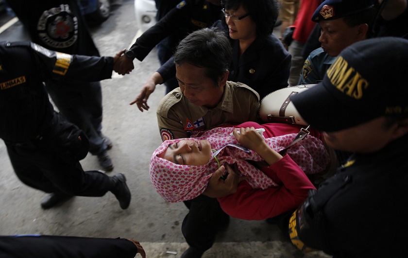 A family member of passengers onboard missing Flight QZ8501 is carried away after she collapsed at Juanda International Airport, Surabaya, December 30, 2014. u00e2u20acu201d Reuters pic