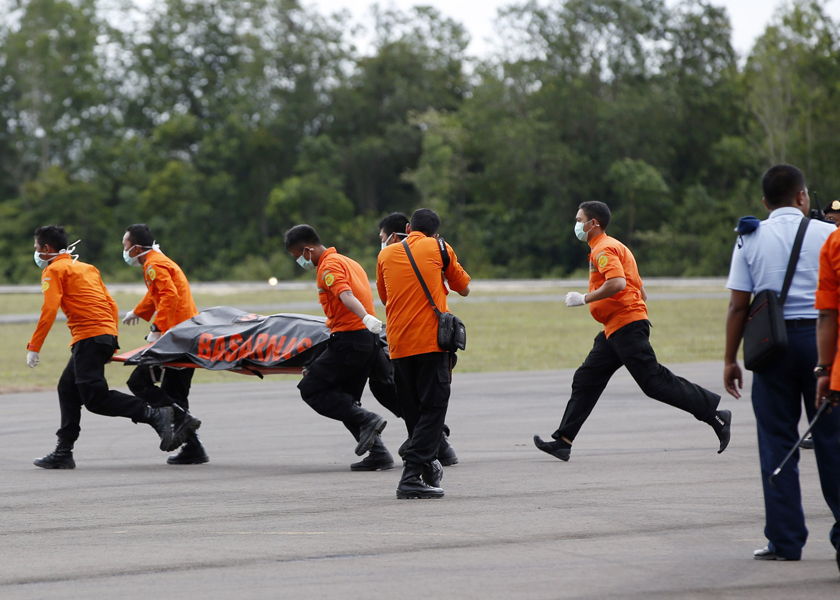Search and rescue team members run as carry the dead body of a passenger onboard AirAsia QZ8501 at Iskandar airbase in, Indonesia, December 31, 2014.u00e2u20acu201d Reuters pic