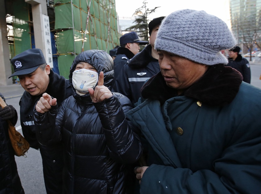 A policeman stops family members of passengers onboard Malaysia Airlines Flight MH370 which disappeared on March 8, 2014, who are trying to enter the Foreign Ministryu00e2u20acu2122s headquarters in Beijing December 19, 2014. u00e2u20acu201d Reuters pic