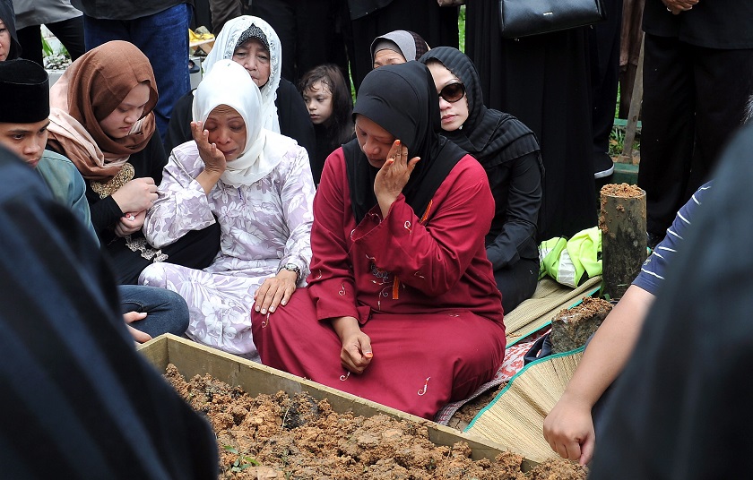 Family members of late veteran actor Datuk Mustapha Maarof perform the funeral rites at the Jalan Ampang Muslim cemetery in Kuala Lumpur, December 15, 2014. u00e2u20acu201d Bernama pic